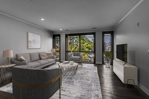 a living room with a grey couch and a tv at Nineteen North Apartments , Buffalo